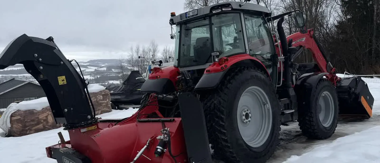 Traktor med snøfreser rydder snø