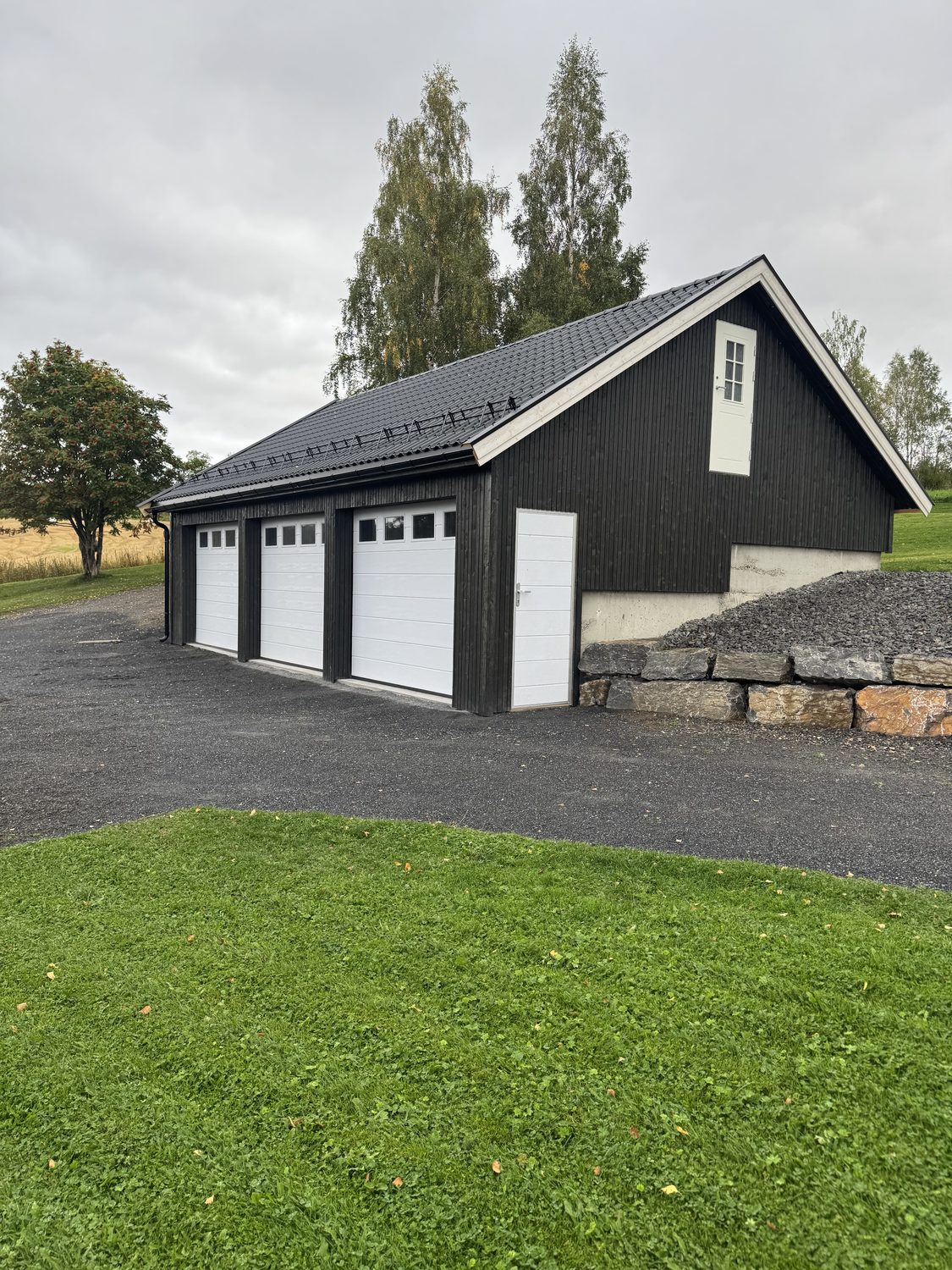 Ferdig garasje med støttemur i naturstein og opparbeidet plass